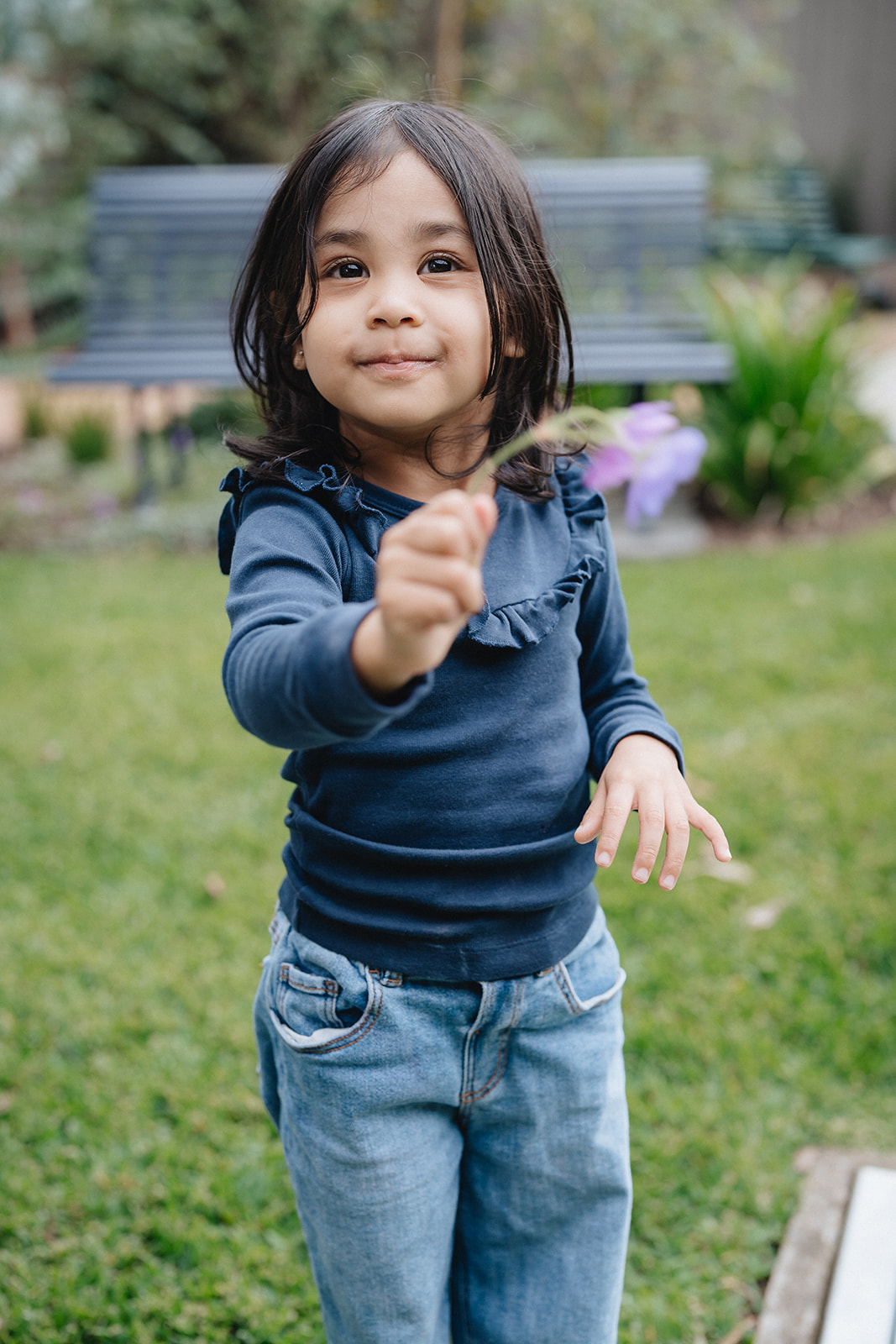 A smiling toddler holding a flower at a Karitane Toddler Clinic