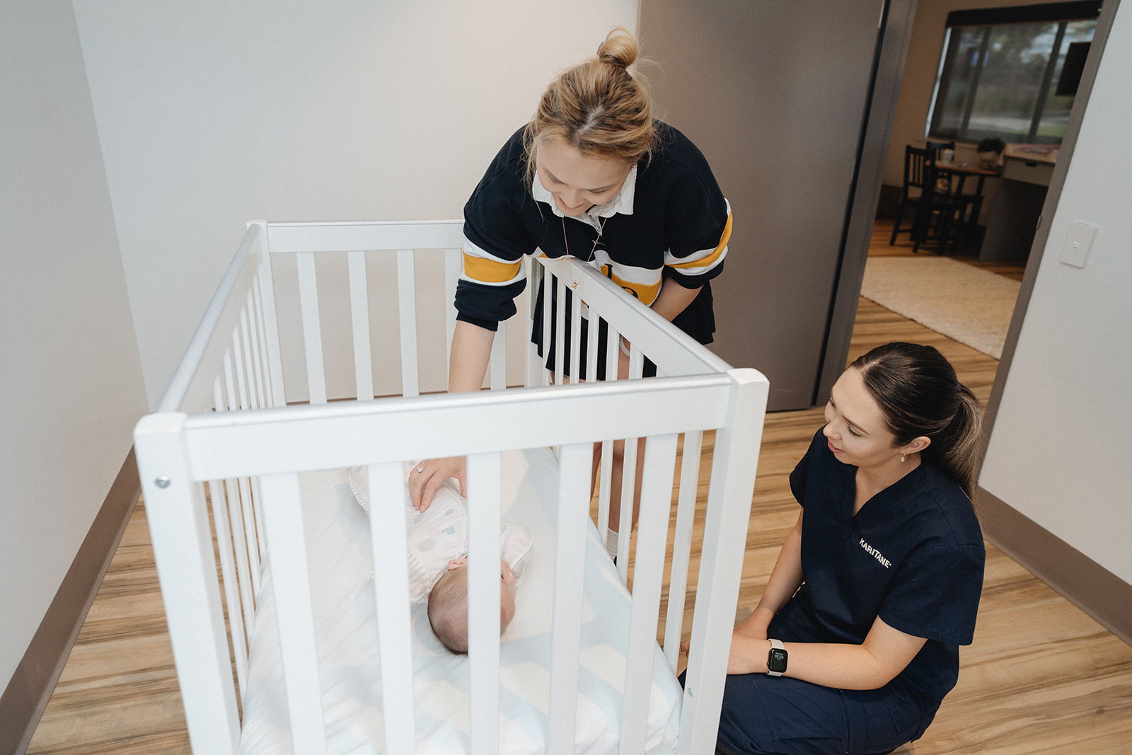A Karitane Nurse with a mother and baby in a cot